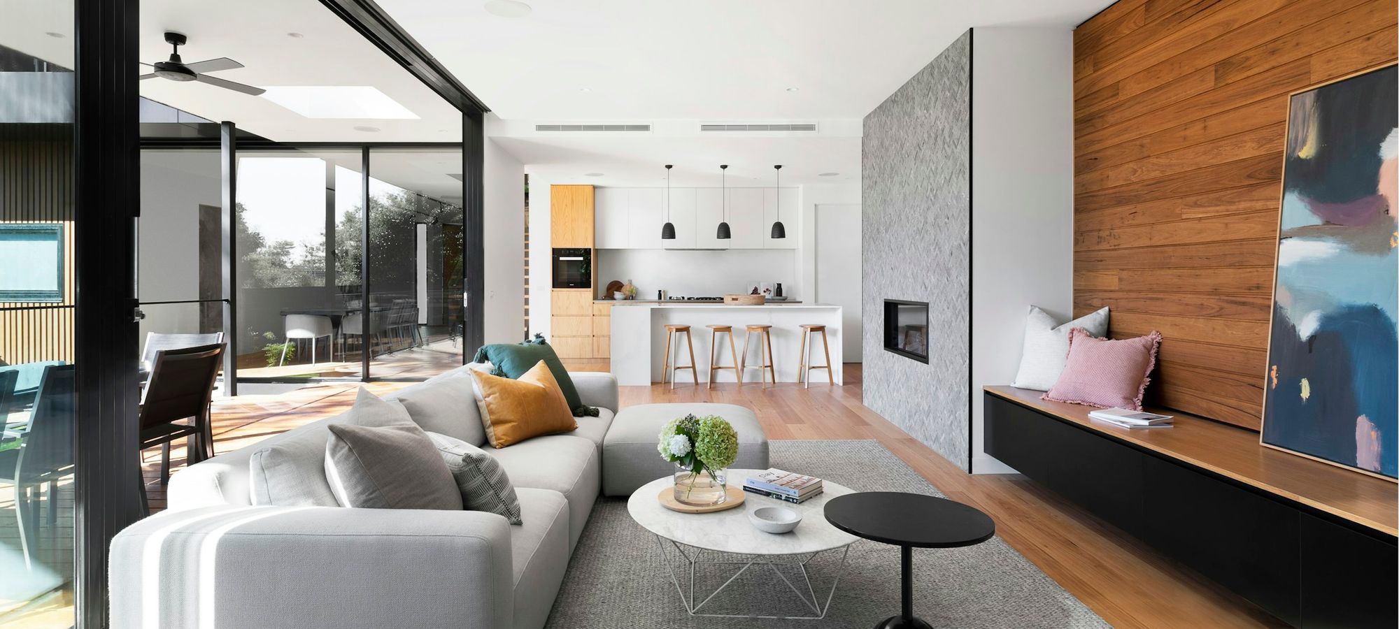 Salón y cocina abiertos tras una reforma integral, con madera y tonos claros